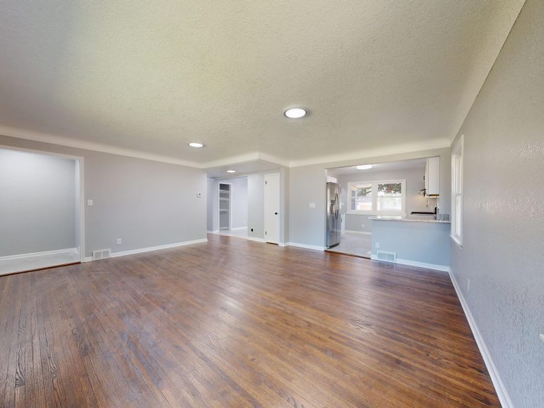 Dark hardwood flooring in an empty Arkansas room with tall windows