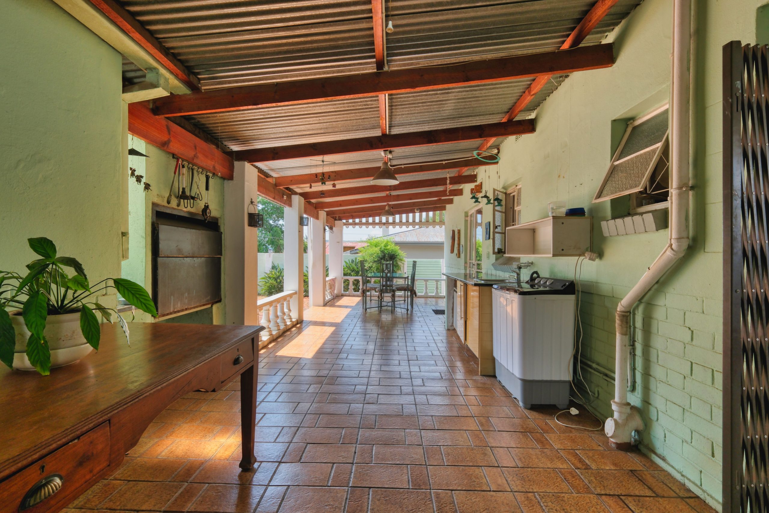 A covered Arkansas porch with a timber ceiling and a hard-wearing deck floor opening onto the yard